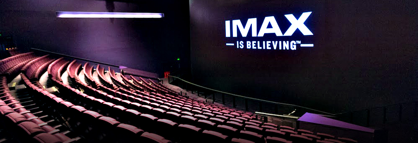 Empty IMAX Theatre displaying 'IMAX is believeing' on the IMAX screen