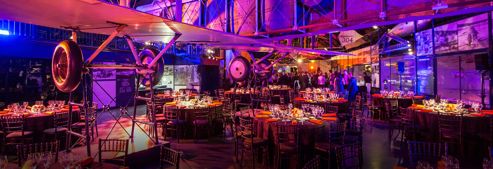 Flight gallery with round dressed tables at a corporate evening event