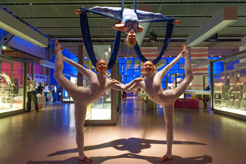 Acrobatic dancers pose in the Who Am I? gallery